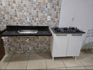 una cocina con fregadero y estufa en casa de temporada, en Goiânia