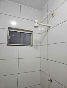 y baño con ventana y ducha. en casa de temporada, en Goiânia