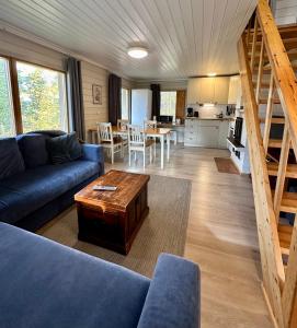 a living room with a blue couch and a table at Hillside Cottage in Ivalo