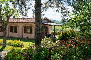 una casa con un jardín con flores y árboles en Villa Roseto Exclusive villa with swimming pool, en San Gimignano