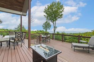 eine Holzterrasse mit einem Tisch und Stühlen darauf in der Unterkunft Long View in Beech Mountain