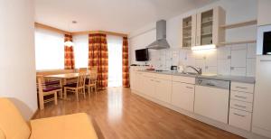 a kitchen with white cabinets and a dining table at Apart Antonia in Ischgl