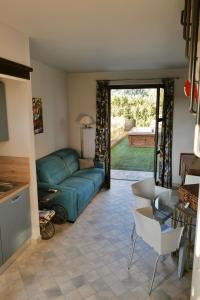 a living room with a green couch and a table at Casa Safranum con mini piscina privata e giardino vista Langhe in Monforte dʼAlba +28 photos