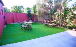 a patio with tables and chairs on green grass at Saint's Inn in Parklands