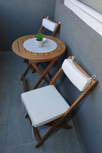 a small table with two chairs and a plant on it at Urban Apartman-privatan parking- in Kraljevo
