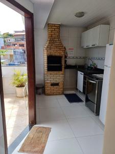 a kitchen with a brick oven in the middle at Acquamarine Hospedagem Apartamento c 2 quartos e suites para casal in Arraial do Cabo +14 photos