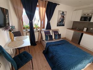 a bedroom with a bed and a table and a kitchen at Royal EvitaBocelli Spodek by walk self check - in in Katowice