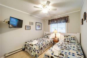 a bedroom with two beds and a flat screen tv at Hike, Golf and Ski Beech Mtn Condo with Resort Perks! in Beech Mountain +20 photos