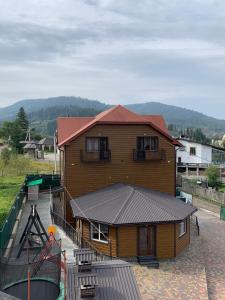 a large wooden house with a metal roof at Аура Карпат in Slavske