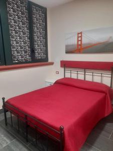 a bedroom with a red bed with a red blanket at B&B da Maria & Renato il Lago Trattoria in Mirabella Eclano