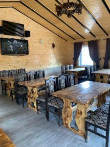 a dining room with wooden tables and chairs at Аура Карпат in Slavske