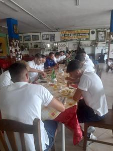 a group of people sitting at a table eating food at B&B da Maria & Renato il Lago Trattoria in Mirabella Eclano