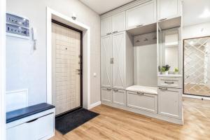 a kitchen with white cabinets and a door with a sink at 2-комнатная квартира Бараева-Валиханова in Astana