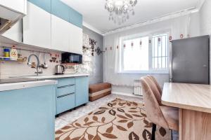 a kitchen with blue cabinets and a counter top at 2-комнатная квартира Бараева-Валиханова in Astana +20 photos