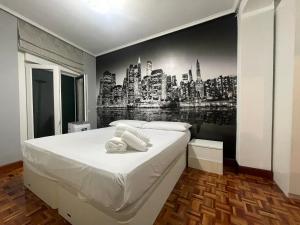 a bedroom with a bed with a city mural on the wall at Encantador apartamento en el centro de Castro CON PARKING in Castro-Urdiales