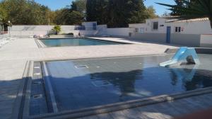 a swimming pool with a slide in front of a building at Mobile-home camping 7 fonts AGDE in Agde