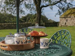 a table with a tray of food and cups on it at Stoney Cliffe Farm in Leek