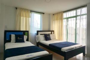 two beds sitting in a room with a window at Finca Hotel La Molienda Quindiana in Montenegro +57 photos