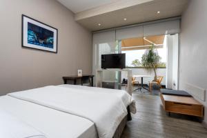 a hotel room with a bed and a desk and a table at Hotel Park 85 in Cali