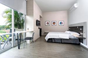 a bedroom with a bed and a desk and a window at Hotel Park 85 in Cali