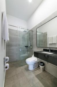 a bathroom with a toilet and a glass shower at Hotel Park 85 in Cali +22 photos