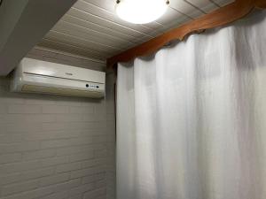 a bathroom with a shower curtain and a light at Pousada dos Pássaros in Gramado