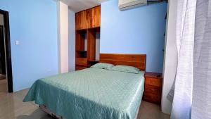 een slaapkamer met een bed met een houten hoofdeinde bij Casa independiente in Bahía de la Academia