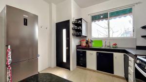 een keuken met een roestvrijstalen koelkast en een raam bij Casa independiente in Bahía de la Academia +11 foto's