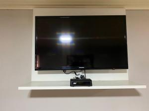 a flat screen tv sitting on a white shelf at Pousada dos Pássaros in Gramado