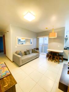 ein Wohnzimmer mit Sofa und Tisch in der Unterkunft Apto Berlanda: Vista Mar e Beto Carrero World in Penha