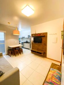 ein Wohnzimmer mit Fernseher und Tisch in der Unterkunft Apto Berlanda: Vista Mar e Beto Carrero World in Penha