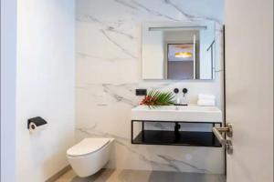 Un baño blanco con lavabo e inodoro. en New apartments near the beach Jan Thiel Curacao, en Jan Thiel 8 fotos más