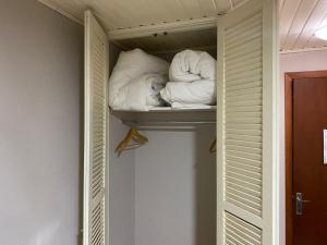 a closet with two pillows and a dog on a shelf at Pousada dos Pássaros in Gramado