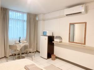 a room with a table and a mirror and a microwave at Jo Hometel in Lak Si +5 photos