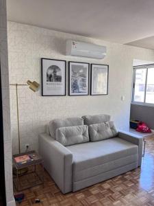 a couch in a living room with pictures on the wall at Luminoso y confortable apartamento en el corazón de la ciudad in Montevideo