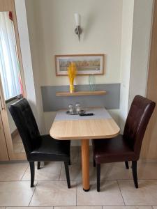 a dining room with a table and two chairs at Hotel Pfälzer Hof in Enkenbach-Alsenborn +17 photos