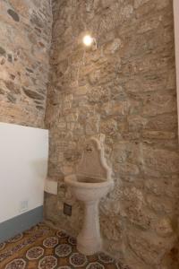 a stone bathroom with a toilet in a stone wall at Palazzo Antico in Ascoli Piceno +26 photos