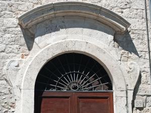 an arch over a door in a stone building at Palazzo Antico in Ascoli Piceno