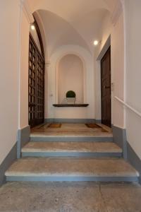un corridoio con scale che conducono a una porta di Palazzo Antico ad Ascoli Piceno