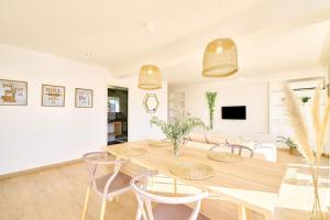 un salon blanc avec une table et des chaises en bois dans l'établissement El mirador de Plasencia by keyhom, à Plasence