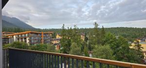 a balcony with a view of a town with trees at Apartman so saunou, PRIMO Stary Smokovec in Smokovce