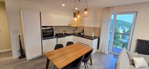 a kitchen with a wooden table and a dining room at Apartman so saunou, PRIMO Stary Smokovec in Smokovce