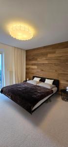 a bedroom with a large bed with a wooden wall at Apartman so saunou, PRIMO Stary Smokovec in Smokovce
