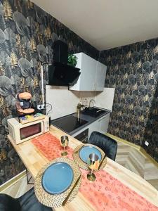 una cocina con una mesa con placas azules. en Loveroom 50 nuances de bulles jacuzzi et sauna privatif, en Lens 5 fotos más