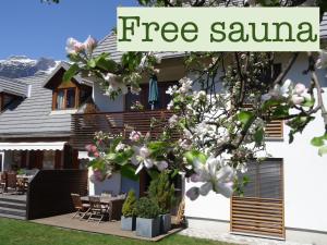 博维茨Apartments Supermjau的一栋房子，前面有一棵树，上面写着“免费桑拿”