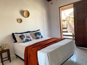 a bedroom with a bed with white sheets and a window at casa flamboyant in Jericoacoara +74 photos