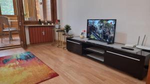 a living room with a flat screen tv on a desk at Feeria National Parc in Bucharest