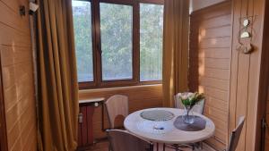 a dining room table with a vase of flowers on it at Feeria National Parc in Bucharest +15 photos