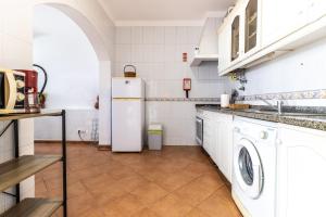a kitchen with a white refrigerator and a washing machine at Urban Beach - A Algarvia in Portimão