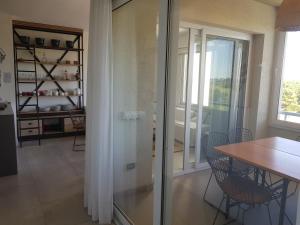 a dining room with a table and a glass door at Departamento con vista al Golf Barrio Costa Esmeralda in Costa Esmeralda +13 photos